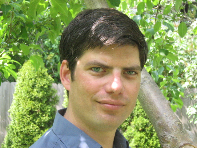 Dale Decker, LCSW smiles and is standing in a garden